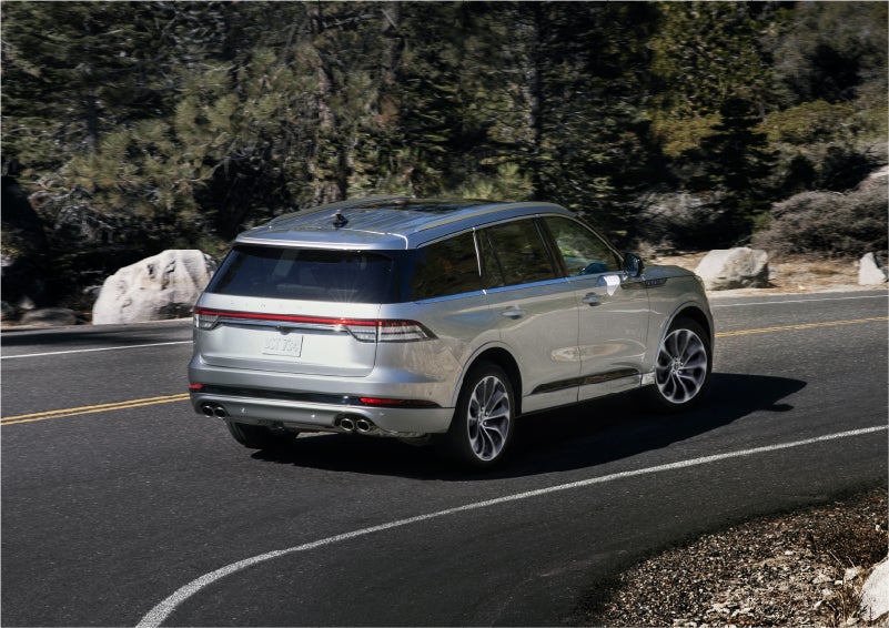 A 2023 Lincoln Aviator® Grand Touring model is shown being driven on a tight turn of a mountain road | Fair Oaks Lincoln in Naperville IL