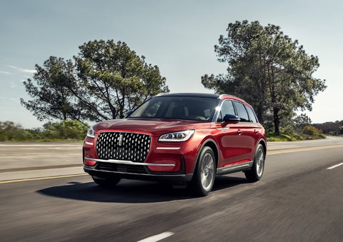 A 2024 Lincoln Corsair® SUV is shown being driven on a country road. | Fair Oaks Lincoln in Naperville IL
