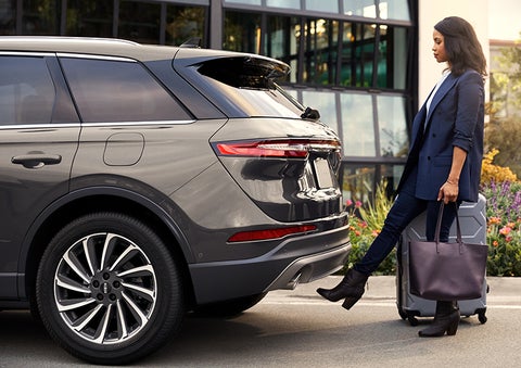 A woman with her hands full uses her foot to activate the available hands-free liftgate. | Fair Oaks Lincoln in Naperville IL