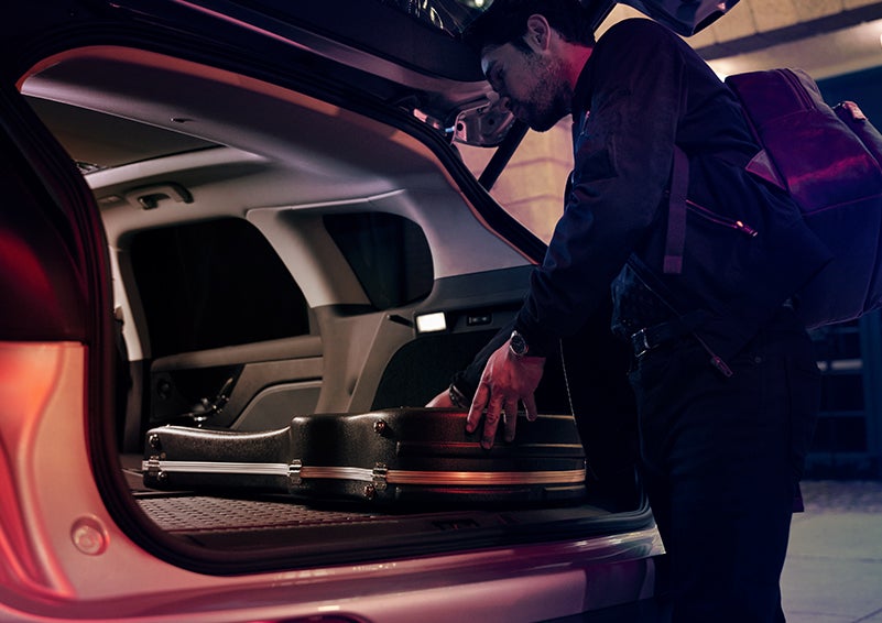 A man is shown loading cargo into the rear of a 2024 Lincoln Corsair® SUV with the second-row seats folded flat. | Fair Oaks Lincoln in Naperville IL