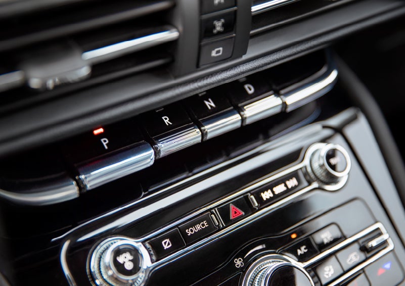 The Park button on the elegant Piano Key Shifter is lit up and engaged as light dances off the chrome accents and horizontal design lines | Fair Oaks Lincoln in Naperville IL