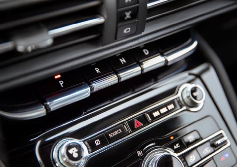 The Park button on the elegant Piano Key Shifter is lit up and engaged as light dances off the chrome accents and horizontal design lines | Fair Oaks Lincoln in Naperville IL