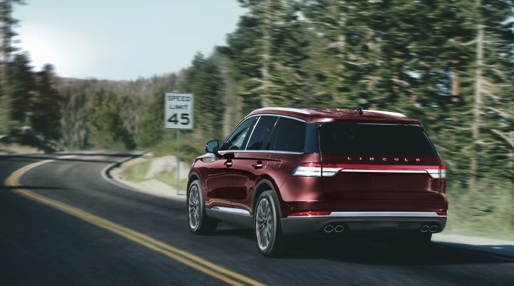 A 2024 Lincoln Aviator® SUV is being driven on a winding mountain road | Fair Oaks Lincoln in Naperville IL