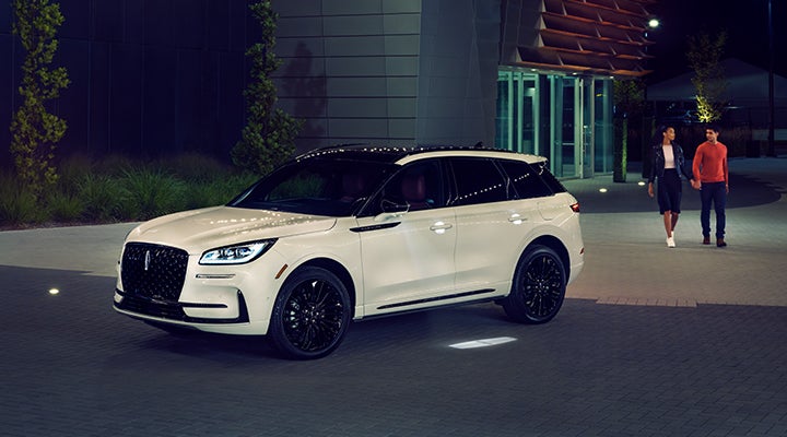 Two people approach a 2024 Lincoln Corsair® SUV featuring the available Jet Appearance Package. | Fair Oaks Lincoln in Naperville IL