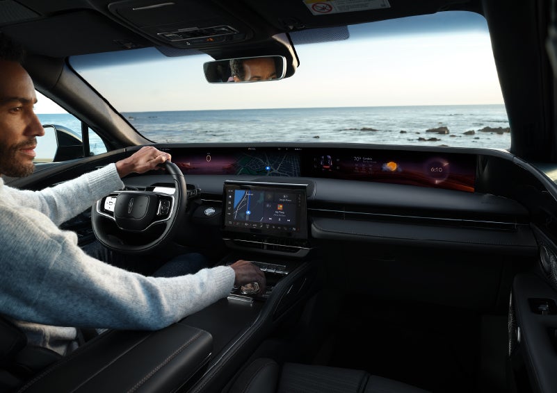 A driver of a parked 2024 Lincoln Nautilus® SUV takes a relaxing moment at a seaside overlook while inside his Nautilus. | Fair Oaks Lincoln in Naperville IL