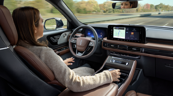 A woman is seen sitting in the driver’s seat of her 2025 Lincoln Aviator® SUV with her hands off the steering wheel. | Fair Oaks Lincoln in Naperville IL
