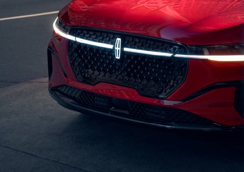 The available front LED light bar and center Lincoln Star logo glow at dusk. | Fair Oaks Lincoln in Naperville IL