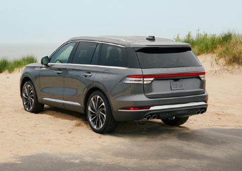 A 2027 Lincoln Aviator® SUV is parked next to sand dunes. | Fair Oaks Lincoln in Naperville IL