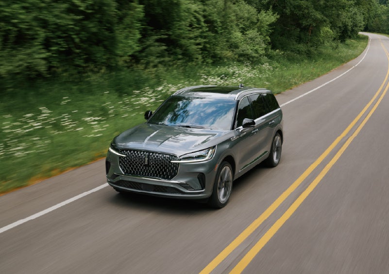 A 2027 Lincoln Aviator® SUV is being driven down a road. | Fair Oaks Lincoln in Naperville IL