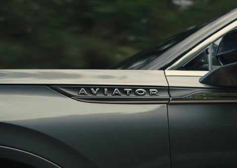 The driver’s side door and fender badging of a gray 2027 Lincoln Aviator® SUV are showcased. | Fair Oaks Lincoln in Naperville IL